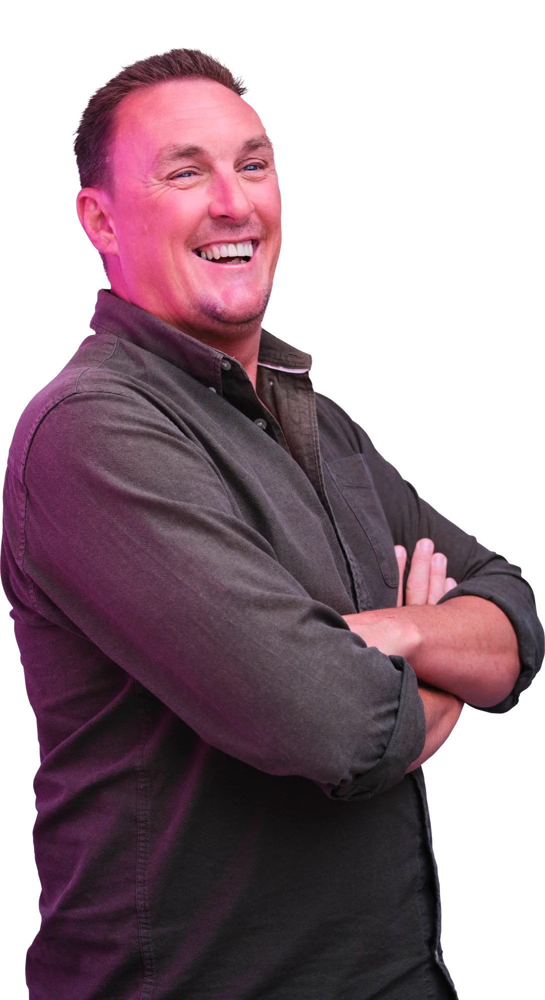 Smiling man with arms crossed, wearing a dark shirt.