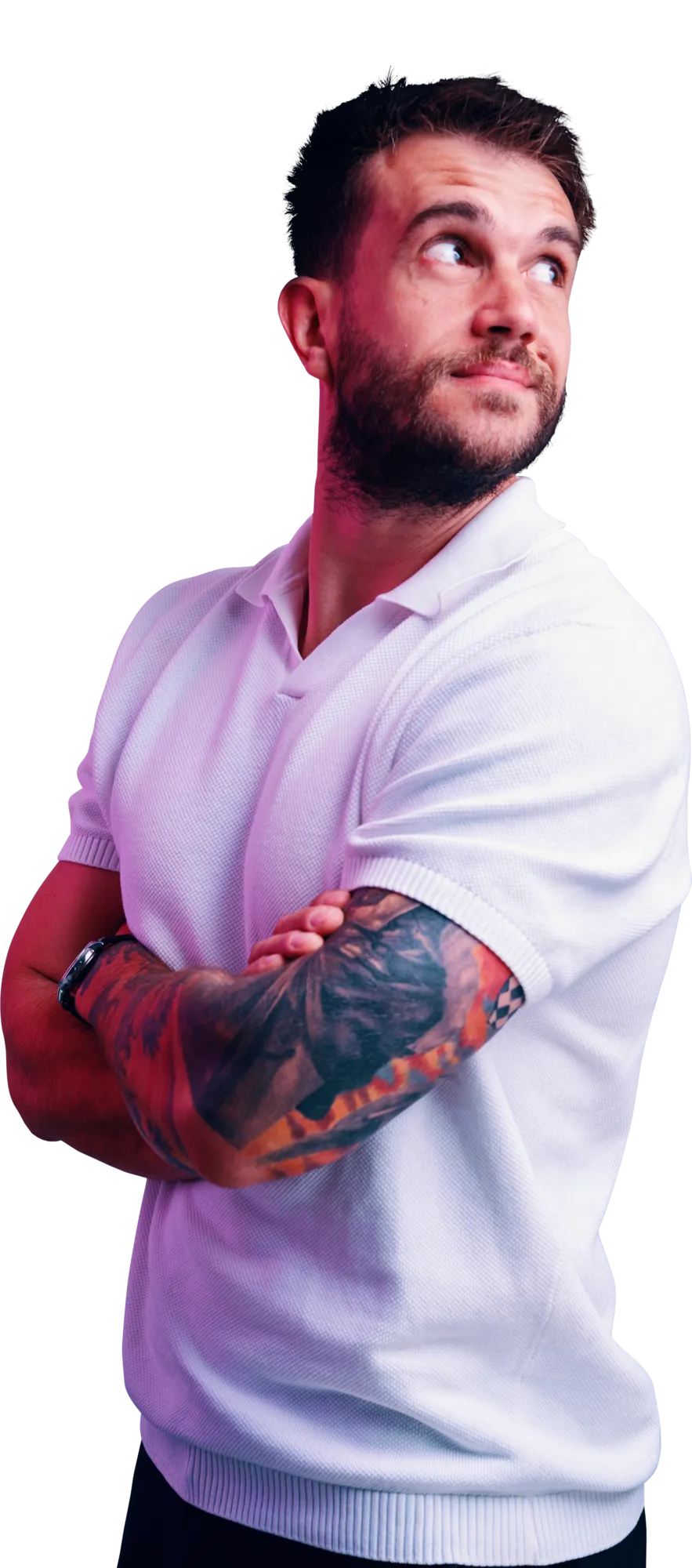 Man with a beard and tattooed arm, wearing a white polo shirt with arms crossed and looking off to the side.