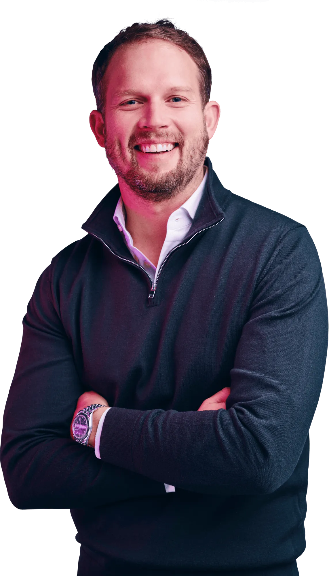 Smiling man with short brown hair and a beard, wearing a navy sweater over a light blue collared shirt, arms crossed.
