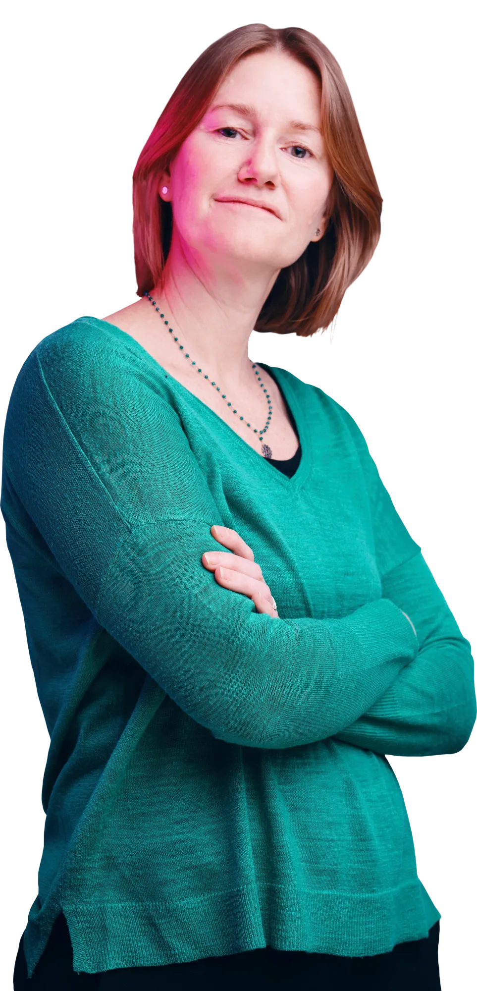 Woman with short red hair in a teal sweater, wearing a necklace, with arms crossed.