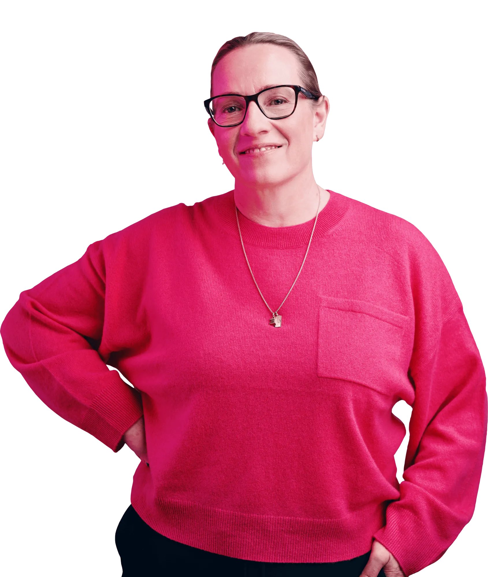 Person wearing a pink sweater and glasses, smiling with one hand on their hip.
